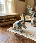 Elefante in ceramica di Caltagione realizzato a mano, animali portafortuna art. piede su  azzurro